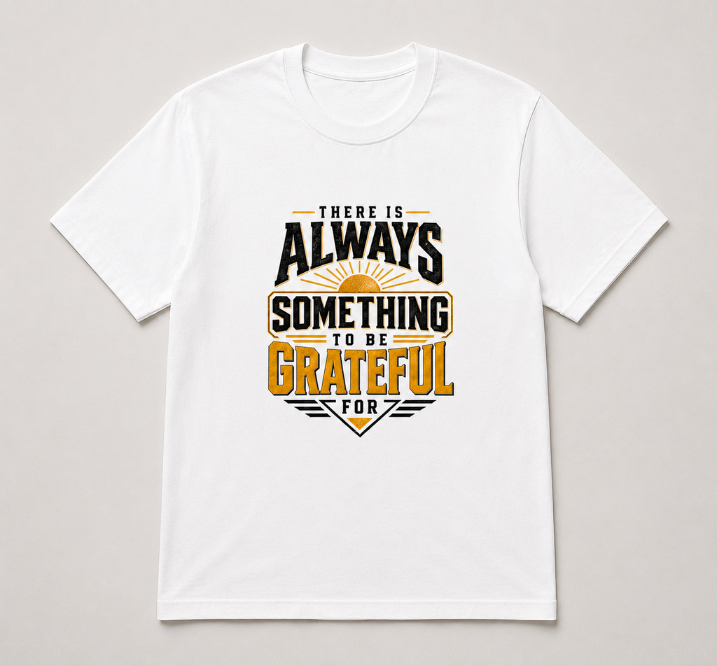 A white short-sleeve crewneck t-shirt with a graphic print on the front that reads 'THERE IS ALWAYS SOMETHING TO BE GRATEFUL FOR' in black and gold lettering with a sunburst design, displayed flat against a light gray background.