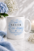 White gloss ceramic mug featuring the Never Lose Hope Watercolour Serenity design with a soft blue watercolour background from the Keep Your Spirit Alive® collection.