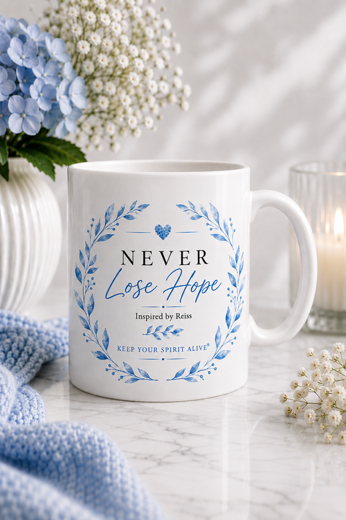 White gloss ceramic mug featuring the Never Lose Hope Inspired by Reiss design with a blue botanical wreath from the Keep Your Spirit Alive® collection.