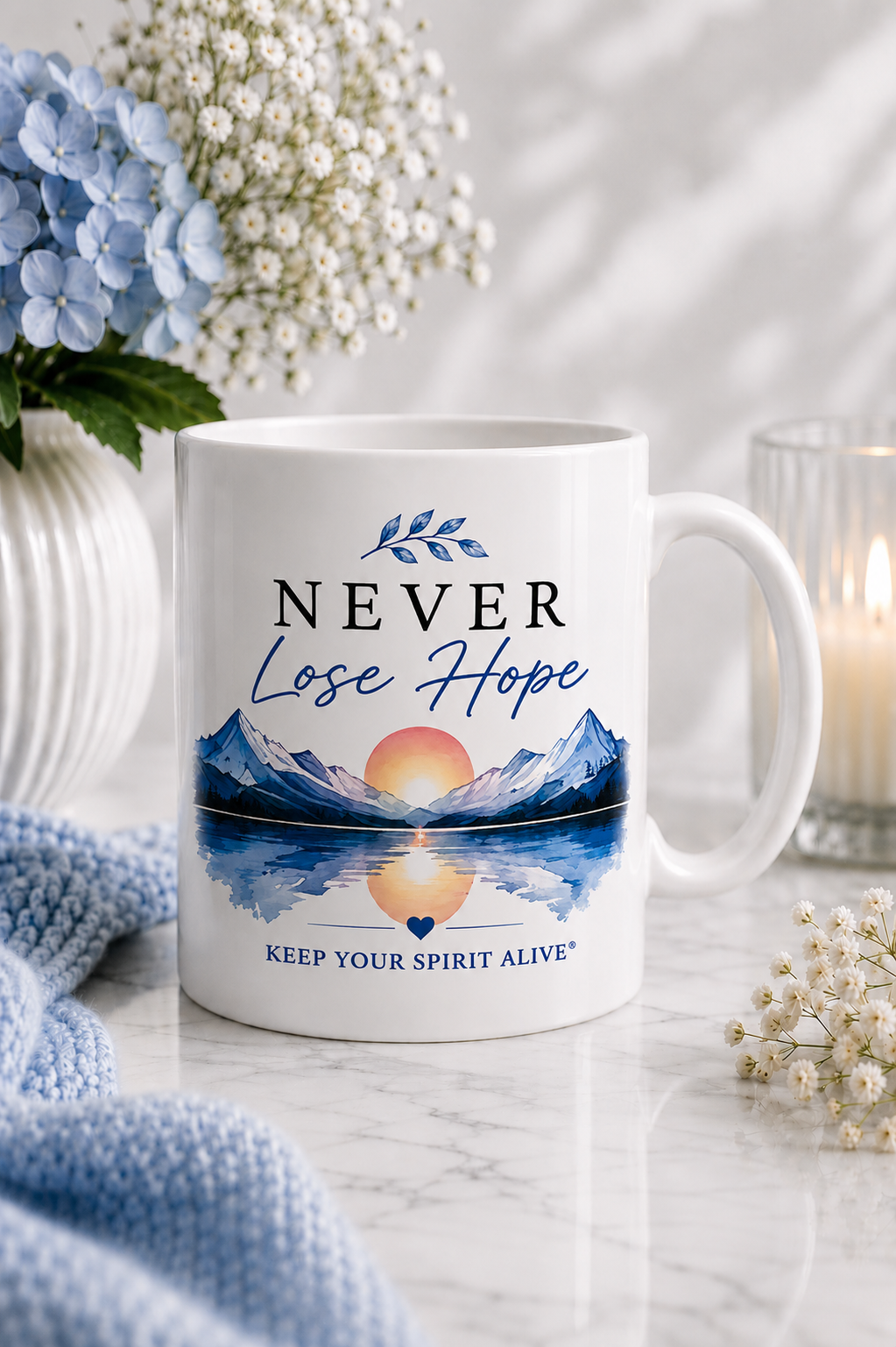 White gloss ceramic mug featuring the Never Lose Hope Sunrise Reflection design with blue mountains, a glowing sunrise and mirrored lake from the Keep Your Spirit Alive® collection.